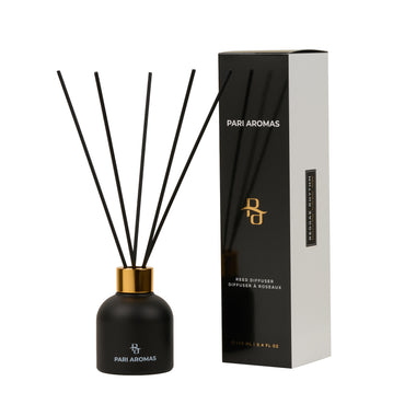 Reggae Rhythm reed diffuser with Moroccan rose, tonka bean, and amber in a clear bottle with natural fragrance reeds