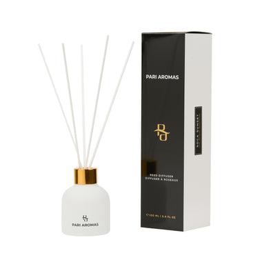 Soca Sunset reed diffuser with lime, gardenia, and sweet amber in a glass vessel with natural reeds for a tropical scent